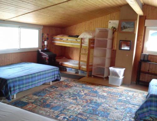 Cette chambre comprend 2 lits superposés et un tapis. dans l'établissement Village de l'herbe réf 2094, à Lège-Cap-Ferret