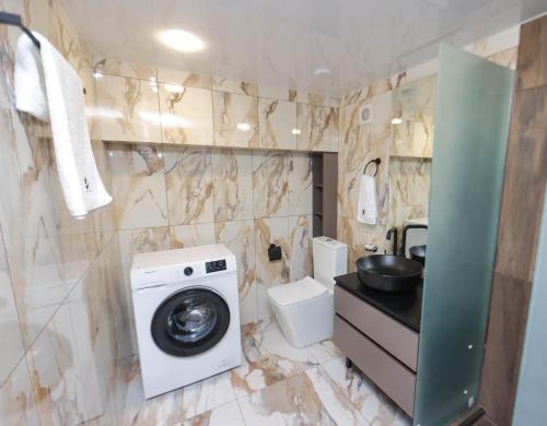 a bathroom with a washing machine and a toilet at Aygestan plaza in Yerevan
