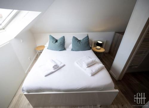 ein Bett mit weißer Bettwäsche und blauen Kissen darauf in der Unterkunft La Traversière 7 / Proche Gare in Tours