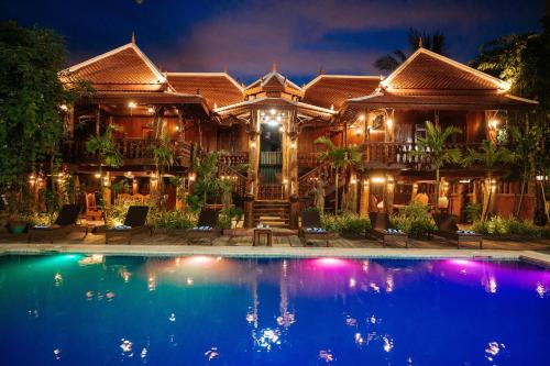 a house with a swimming pool at night at Srey Krob Leak Resort in Battambang