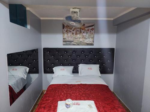 a small bedroom with a bed with a red blanket at hostal paris in Lima