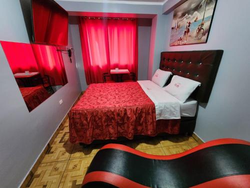 Habitación pequeña con cama con cortinas rojas en hostal paris, en Lima