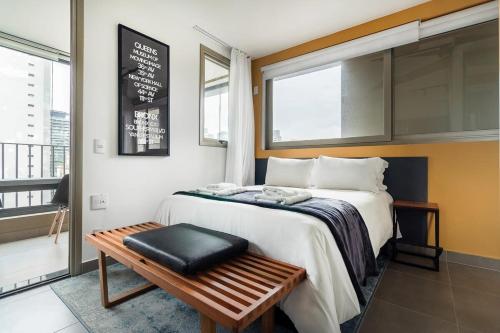 a hotel room with a bed and a bench at BHomy Melo in Sao Paulo