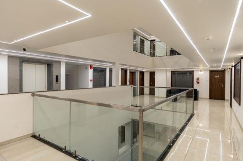 un couloir vide avec un escalier en verre dans un bâtiment dans l'établissement The Living Hub Business Hotel, Kolhapur, à Kolhapur