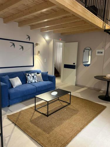 a living room with a blue couch and a table at Living Yard Thissio in Athens