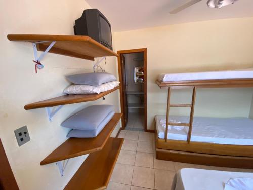 Cette chambre comprend 3 lits superposés et une télévision. dans l'établissement Casa em condomínio fechado Amaralina, à Porto Seguro