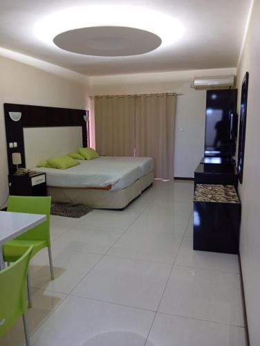 a bedroom with a bed and a flat screen tv at Pensao Martins in Maputo