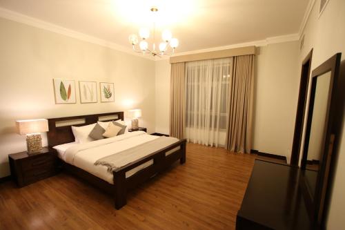 a bedroom with a large bed and a chandelier at Aman Plaza in Juffair
