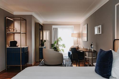 a hotel room with a bed and a living room at AMERON Zürich Bellerive au Lac in Zürich