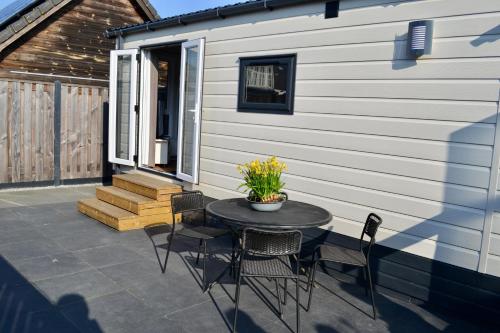 a patio with a table and chairs next to a building at Chalet 27 in Zandvoort