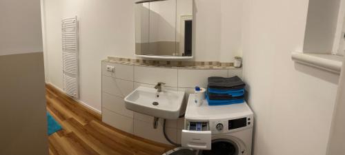 a bathroom with a sink and a washing machine at Zum Karl in Wurzen