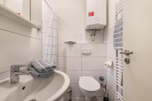 een witte badkamer met een toilet en een wastafel bij Ferienhaus Ostseeblick in Munkbrarup