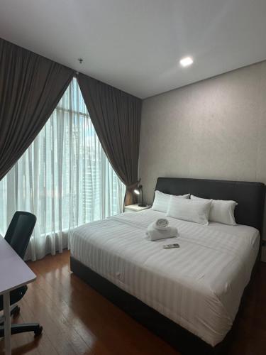 a bedroom with a large bed and a large window at Soho Suites KLCC by Angel in Kuala Lumpur