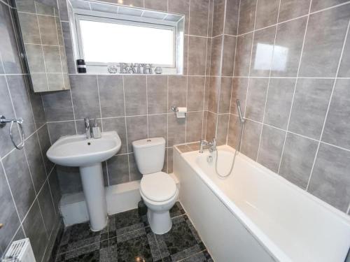 een badkamer met een toilet, een wastafel en een bad bij Diamond house in Darlaston