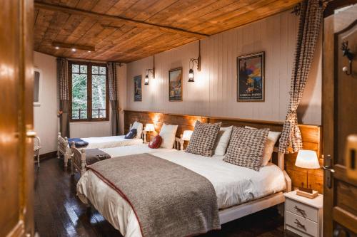 1 dormitorio con 2 camas y 2 ventanas en Les Ruisseaux, en Cauterets