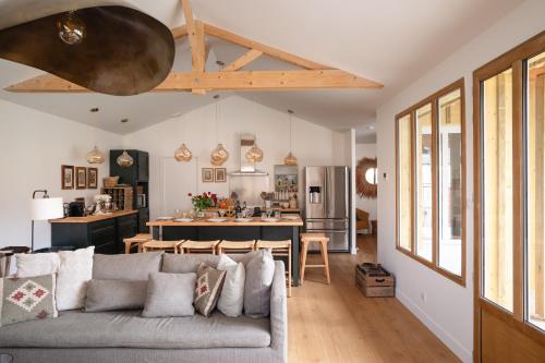 un salon avec un canapé et une cuisine dans l'établissement La Cabane - Maison moderne proche port de Dahouët, à Pléneuf-Val-André