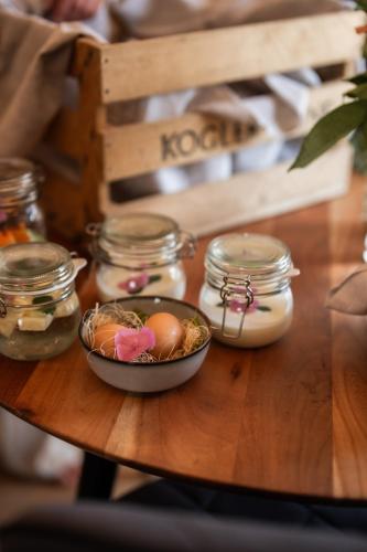 a table with a bowl of eggs and jars on it at Winzer Appartements Kogler in Leutschach