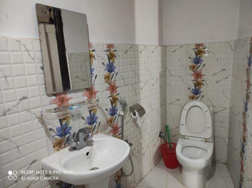 W łazience znajduje się umywalka, toaleta i lustro. w obiekcie Lake View Lodge Sarangkot w mieście Pokhara