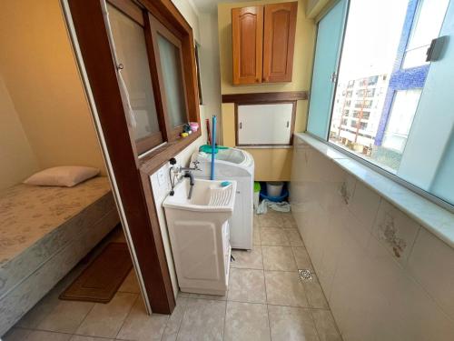 ein kleines Bad mit einem Waschbecken und einem Waschbecken in der Unterkunft Apartamento a uma quadra da praia in Capão da Canoa