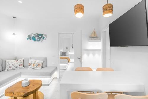 een witte woonkamer met een bank en een tafel bij August Mykonos in Mykonos-stad