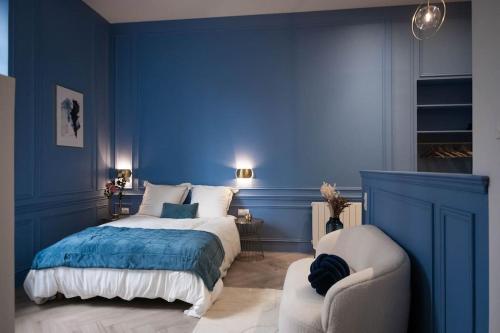 a blue bedroom with a bed and a chair at Le secret d'Ondine - Centre ville in Aix-les-Bains