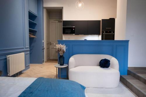 a bedroom with a white chair and a blue wall at Le secret d'Ondine - Centre ville in Aix-les-Bains
