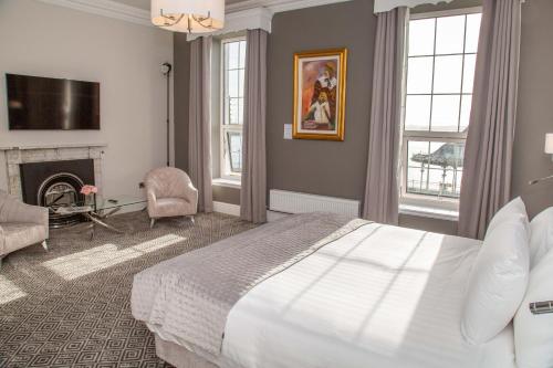 ein Schlafzimmer mit einem großen Bett und einem Kamin in der Unterkunft Commodore Hotel in Cobh