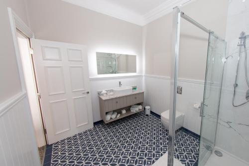 a bathroom with a shower and a sink and a toilet at Commodore Hotel in Cobh