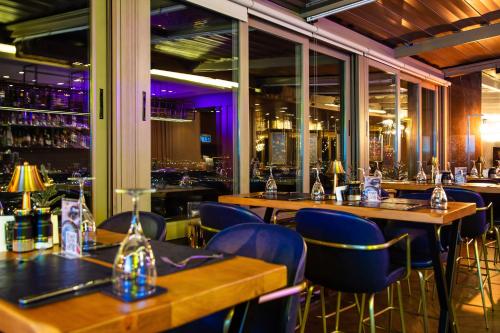a restaurant with wooden tables and blue chairs at Marigold Thermal & Spa Hotel Bursa in Bursa