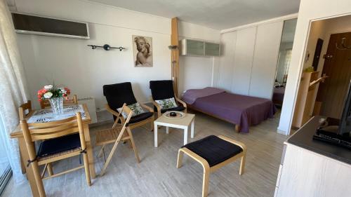 une petite pièce avec un lit, une table et des chaises dans l'établissement Comfortable studio near the beaches, à Cannes