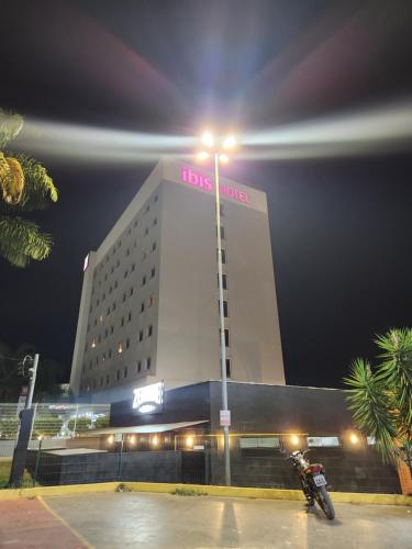 a motorcycle parked in front of a hotel at night at ibis Montes Claros Shopping in Montes Claros