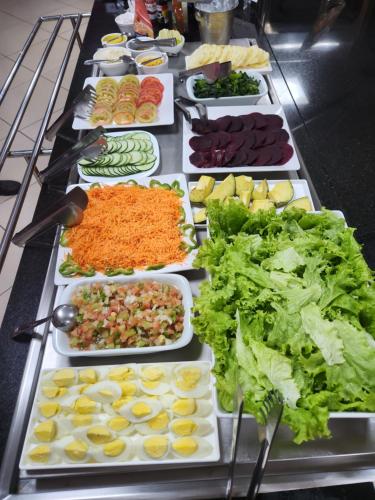 a buffet with many different types of vegetables on plates at ibis Montes Claros Shopping in Montes Claros