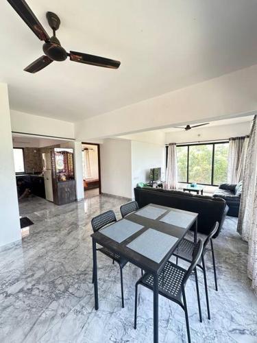 a living room with a ceiling fan and a table and chairs at Granthika’s House in Harnai
