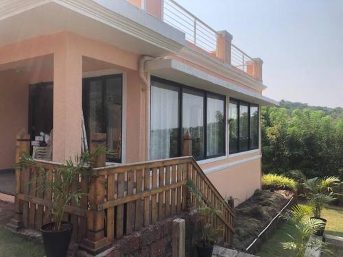 a house with a wooden porch with windows at Granthika’s House in Harnai