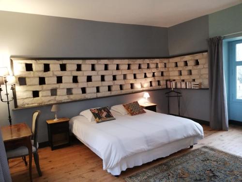 a bedroom with a white bed and a large headboard at Les INSOLITES DE LA TOUCHE in Azay-le-Rideau