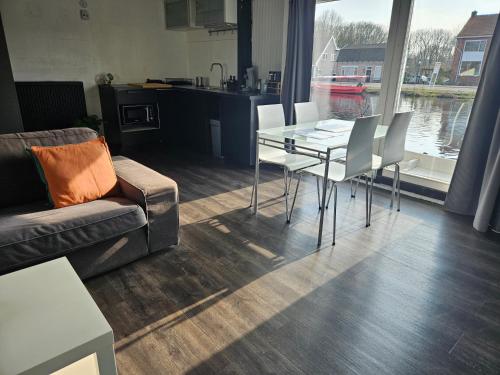 een woonkamer met een glazen tafel en stoelen bij Boathouse Amsterdam in Amsterdam