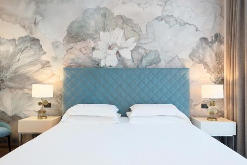 a bedroom with a bed and a floral wall at Hotel Excelsior in Marina di Massa