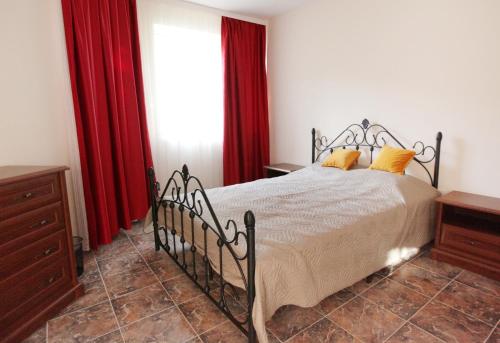a bedroom with a bed with red curtains at Villa Musica in Balchik