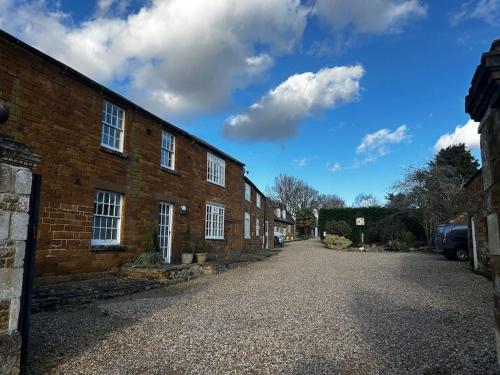 a brick building with white windows on a street at Grouse in Lyddington