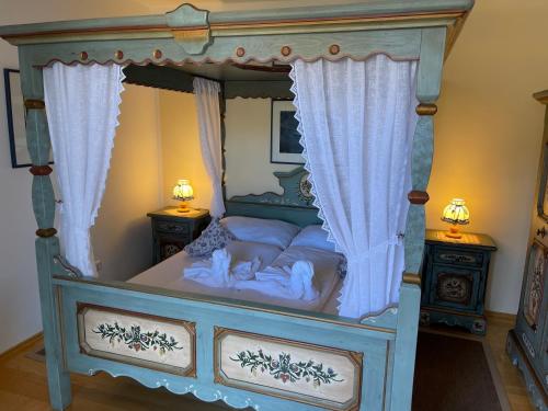 a bedroom with a canopy bed with two night stands at Rosenhof am See Ferienwohnung Enzian in Thiersee