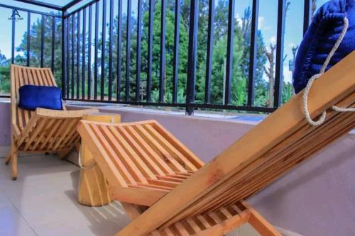 a porch with two wooden chairs and a balcony with a fence at Arctic kerugoya in Keruguya