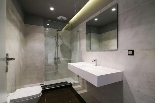 uma casa de banho com um lavatório, um WC e um espelho. em Luxury Beachfront Villa Selenia Gold in Sounio em Sounio