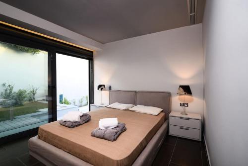 una camera con due letti e una grande finestra di Luxury Beachfront Villa Selenia Gold in Sounio a Sounio