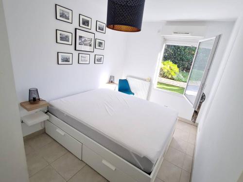 une chambre blanche avec un lit et une fenêtre dans l'établissement T3 en rez-de-jardin avec Wi-Fi et Parking - Plages et commerces à 900m - Terrasse et Jardin privatif - FR-1-316-271, à Six-Fours-les-Plages