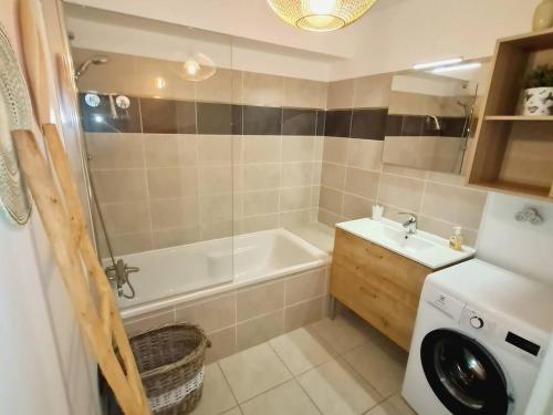 La salle de bains est pourvue d'une baignoire, d'un lavabo et d'un lave-linge. dans l'établissement T3 en rez-de-jardin avec Wi-Fi et Parking - Plages et commerces à 900m - Terrasse et Jardin privatif - FR-1-316-271, à Six-Fours-les-Plages