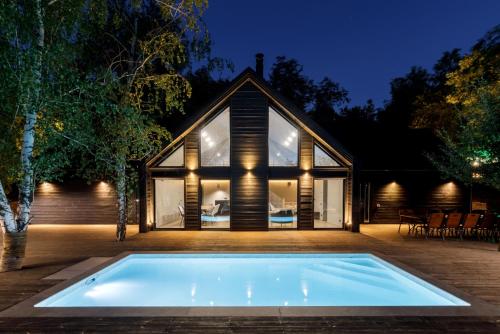 a house with a large swimming pool in front of it at Tree House Relax Park in Chişinău