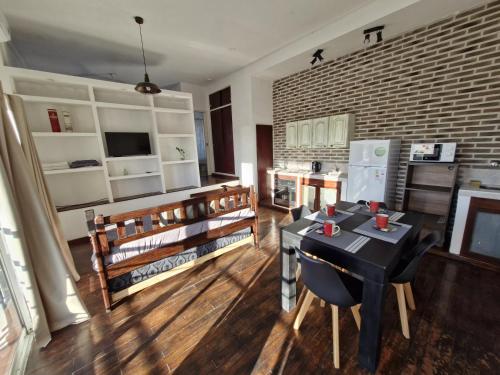 a living room with a table and chairs and a brick wall at Loft con todo que necesitas solo a 2 cuadras de la costanera!! in Corrientes