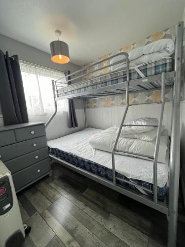 een slaapkamer met 2 stapelbedden in een kamer bij 170 Chalet, Sunbeach, Scratby - Two bed chalet, sleeps 5, pet friendly, free Wi-Fi plus free entry to onsite clubhouse in Scratby