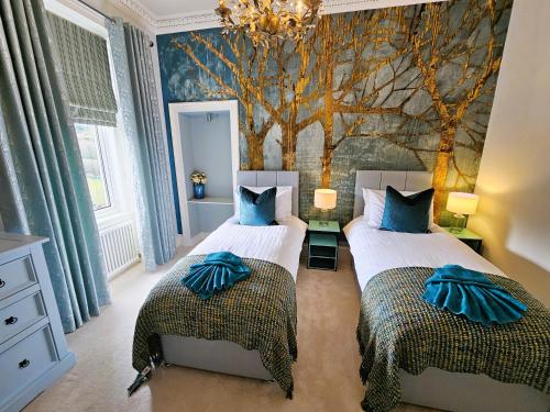 1 dormitorio con 2 camas y un mural de árboles en Merchant's View - Luxury Seaside Designer Retreat en Rothesay