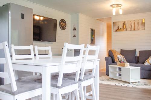 une salle à manger avec une table et des chaises blanches dans l'établissement LE GLAWAN, à Barvaux